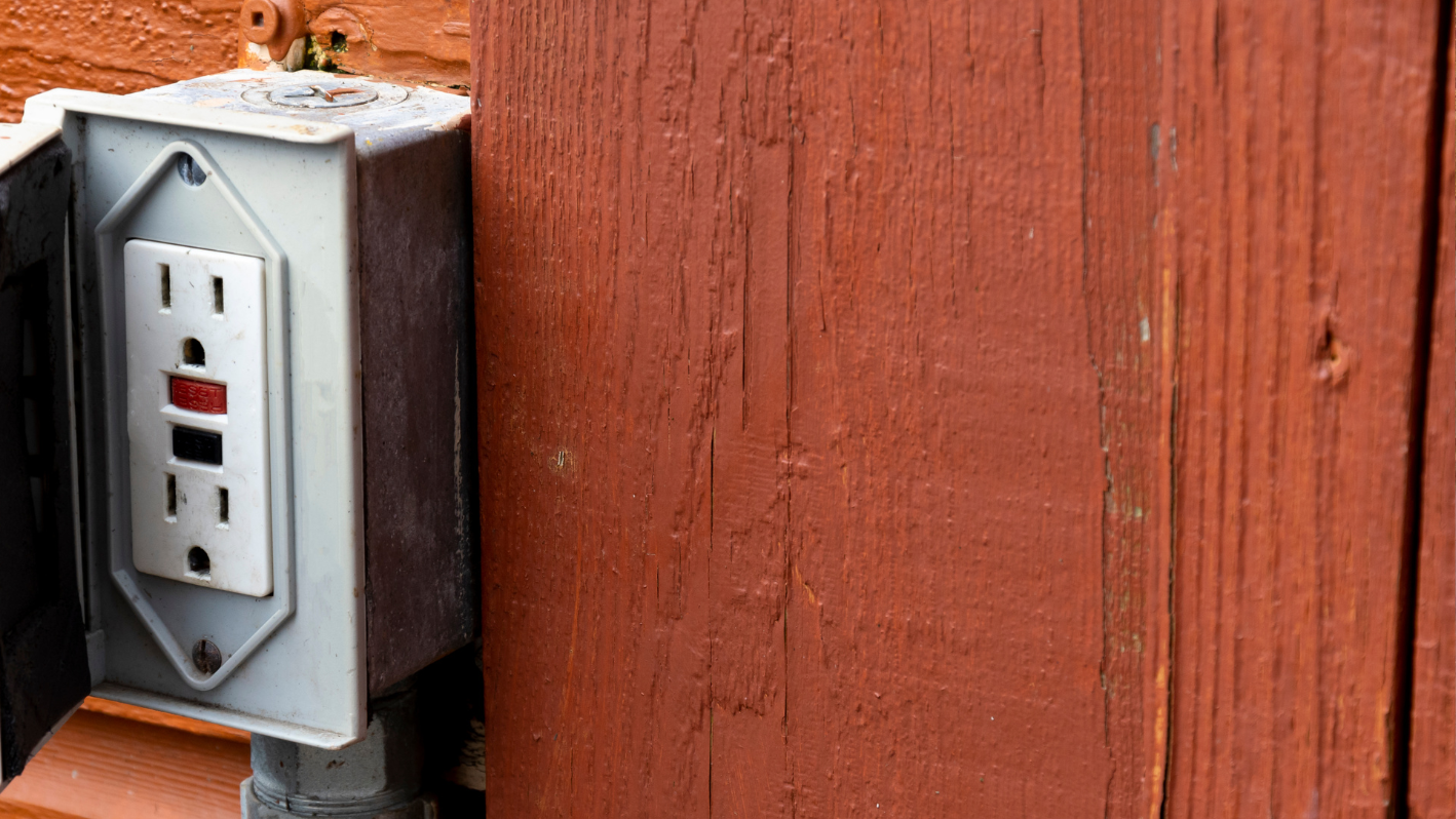 An electrical outlet on the side of a building