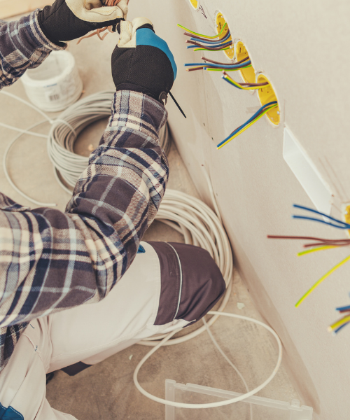 A man is working on a wall with wires