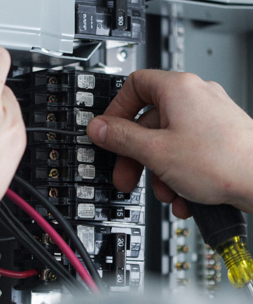 A person is working on an electrical panel